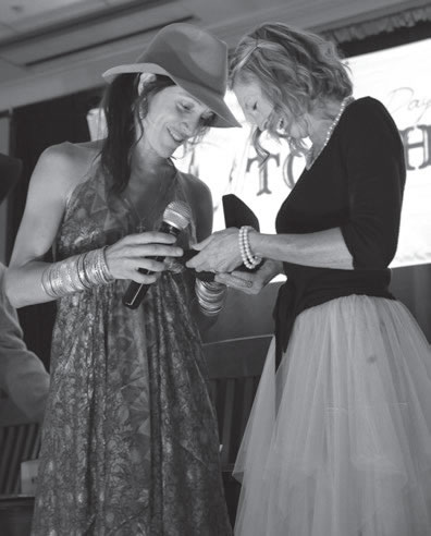 Crested Butte’s Kyleena Falzone (left), a breast cancer survivor, receives a Jimmy Clark commemorative buckle.