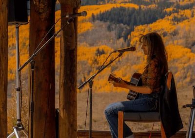 Evelyn Roper playing guitar and singing.
