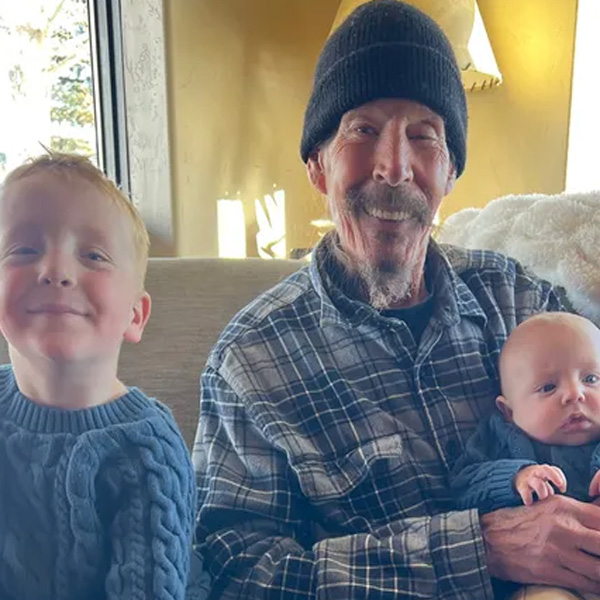 Tim Skulley wearing a winter cap holding his two young grandsons.