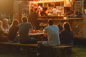 Food Trucks Hungry customers sit at picnic tables and eat terrific food from a food truck.