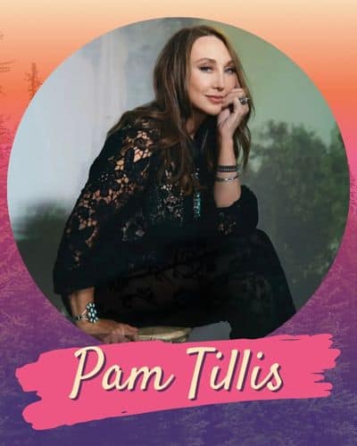 Pam Tillis wearing a black lacy top leaning her chin on her hand.