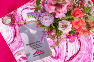 The table centerpieces in pink and fresh flowers along with a program.